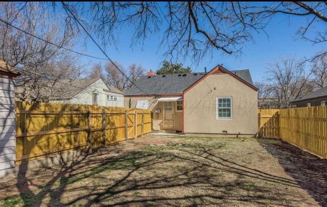 back of house featuring a fenced backyard and stucco siding