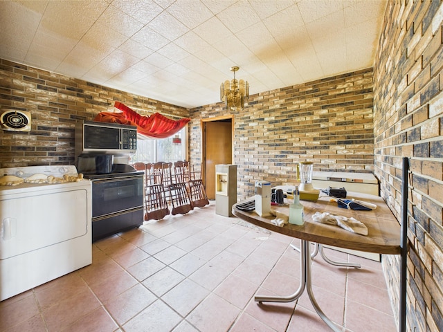 1108 Campanella Dr, Pampa, TX 79065 - dining room with washer / dryer, brick wall, and tile patterned floors