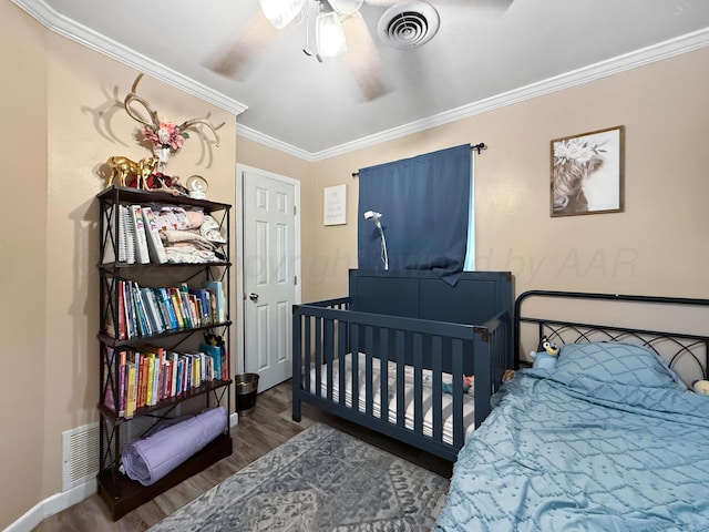 424 Santa Fe St, Borger, TX 79007 - bedroom with wood finished floors, ornamental molding, ceiling fan, baseboards, and a crib
