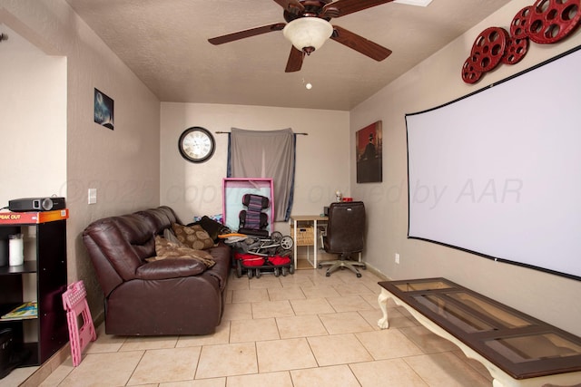 tiled cinema room with a textured ceiling and ceiling fan