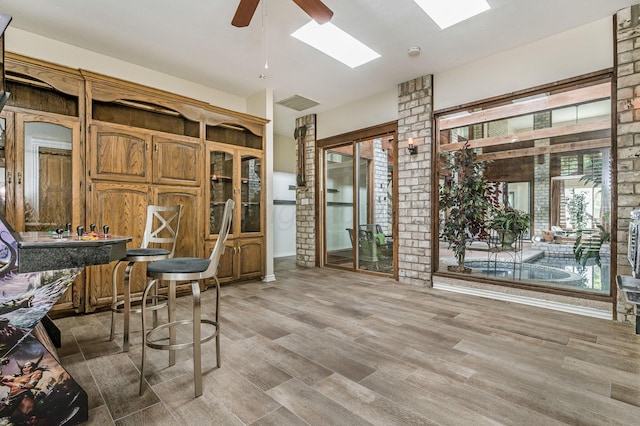 7402 Lynnlee Pl, Amarillo, TX 79121 - dining room featuring ceiling fan, a skylight, light wood-style flooring, and bar