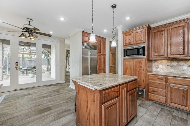 7402 Lynnlee Pl, Amarillo, TX 79121 - kitchen with built in appliances, light wood-style floors, brown cabinets, recessed lighting, and backsplash