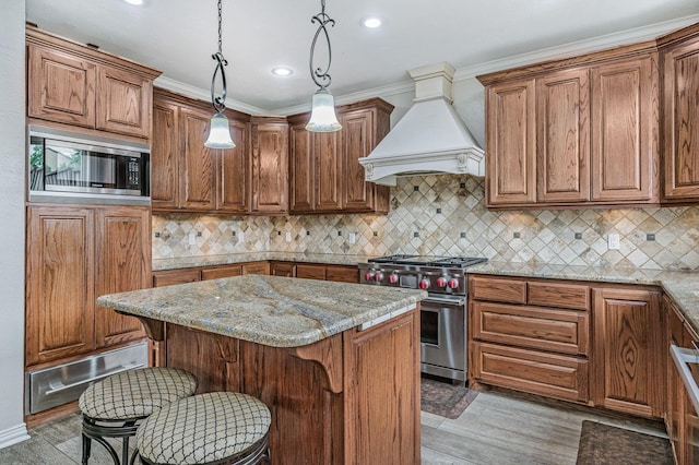 7402 Lynnlee Pl, Amarillo, TX 79121 - kitchen with appliances with stainless steel finishes, a warming drawer, custom range hood, light wood-style flooring, and a center island