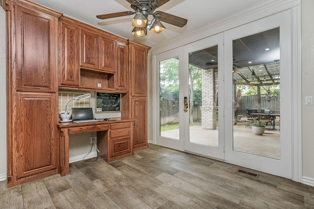 7402 Lynnlee Pl, Amarillo, TX 79121 - unfurnished office featuring french doors, wood finished floors, built in desk, and ceiling fan
