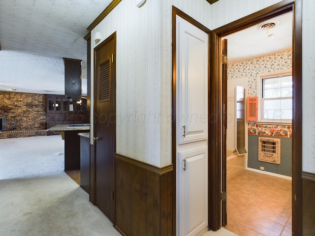 1924 N Dwight St, Pampa, TX 79065 - corridor with visible vents, wallpapered walls, heating unit, wainscoting, and light colored carpet