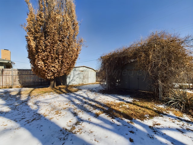 1924 N Dwight St, Pampa, TX 79065 - yard covered in snow featuring an outdoor structure, fence, and a storage shed