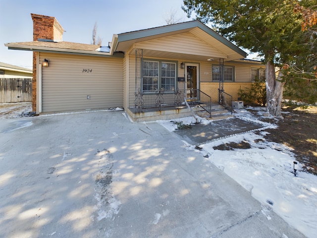 1924 N Dwight St, Pampa, TX 79065 - view of front facade with a chimney, fence, and brick siding