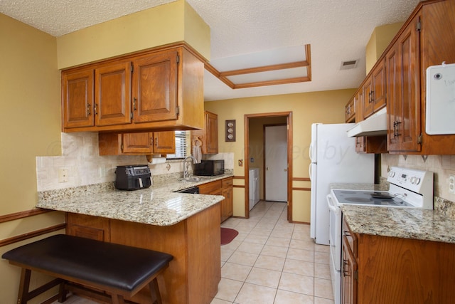 8001 Arbor St, Amarillo, TX 79110 - kitchen featuring electric stove, under cabinet range hood, a peninsula, backsplash, and brown cabinets