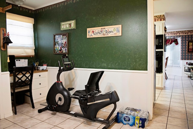 exercise area featuring light tile patterned floors and crown molding