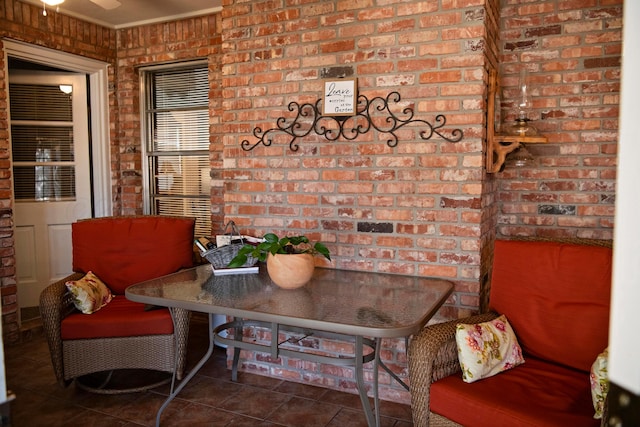 interior space with brick wall and dark tile patterned flooring