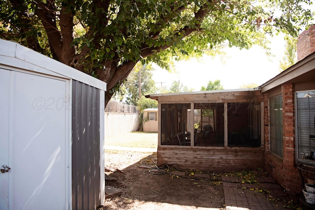 exterior space featuring a storage unit and a sunroom