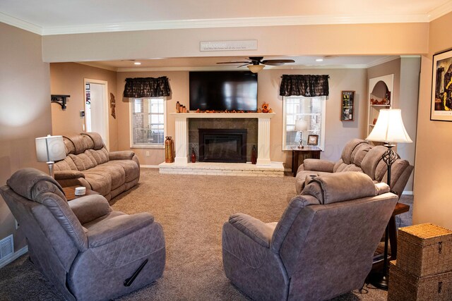 living room featuring ornamental molding, a fireplace, carpet floors, and ceiling fan