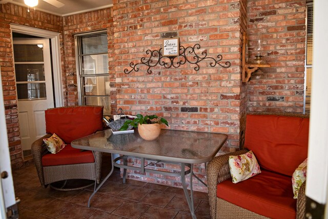 living area featuring brick wall and dark tile patterned floors