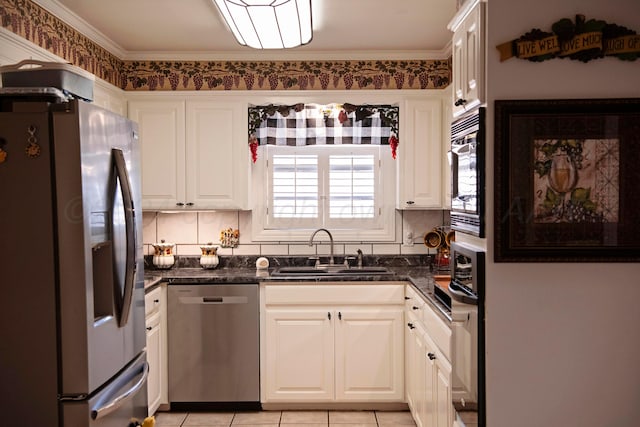 kitchen featuring dark stone counters, white cabinets, sink, and stainless steel appliances