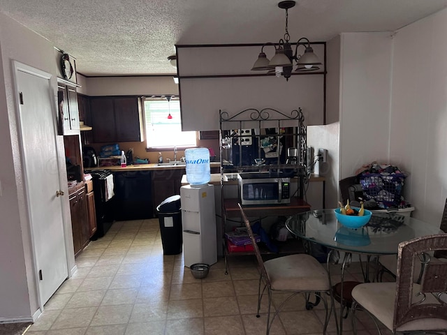 514 Willow Ln, Hereford, TX 79045 - kitchen with stainless steel microwave, a chandelier, a textured ceiling, black stove, and light countertops