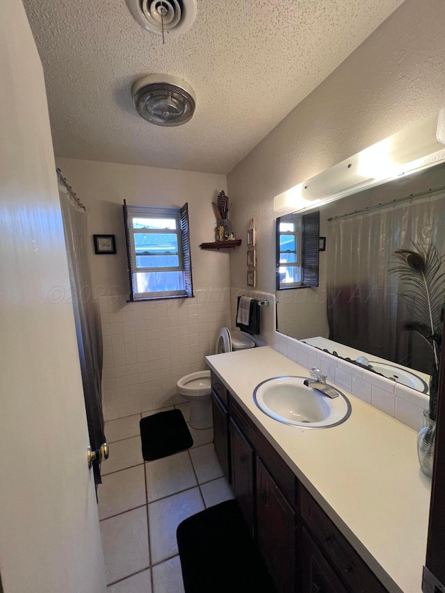 514 Willow Ln, Hereford, TX 79045 - bathroom featuring tile patterned floors, vanity, a textured ceiling, curtained shower, and tile walls