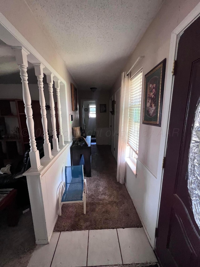 514 Willow Ln, Hereford, TX 79045 - corridor featuring a textured ceiling, carpet floors, and tile patterned floors