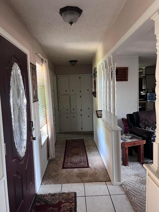 514 Willow Ln, Hereford, TX 79045 - foyer featuring light carpet, a textured ceiling, and light tile patterned floors