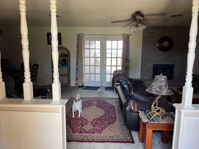 514 Willow Ln, Hereford, TX 79045 - carpeted living area with a ceiling fan, french doors, a textured ceiling, and a fireplace