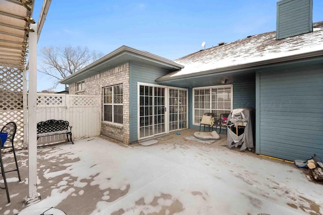 view of patio featuring fence and a grill