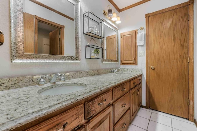 bathroom featuring crown molding, tile patterned floors, a sink, and double vanity