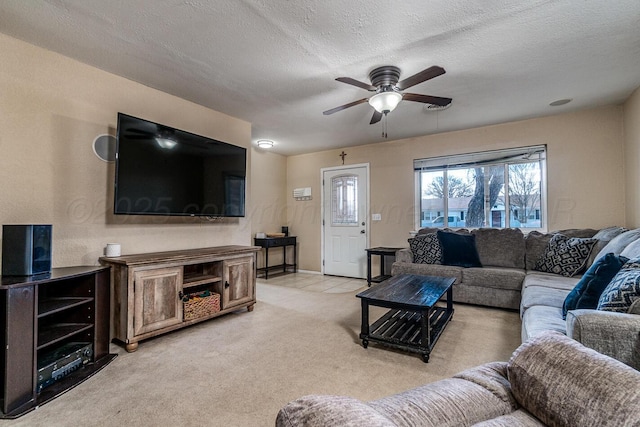 living area featuring a textured ceiling, a ceiling fan, and light colored carpet