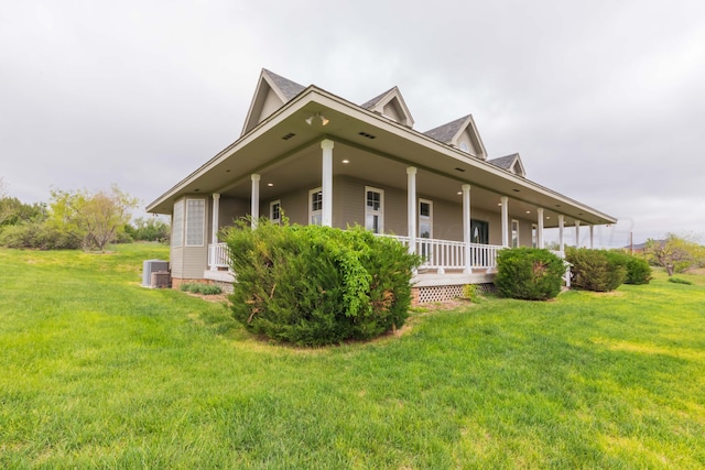 farmhouse inspired home featuring a porch, central AC unit, and a front yard