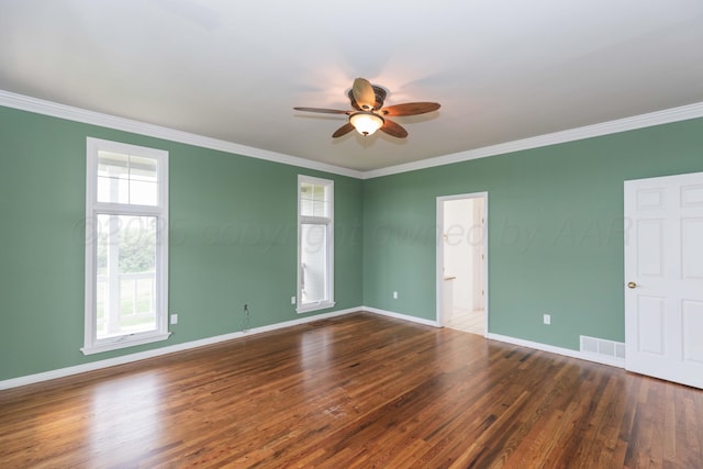 spare room featuring a ceiling fan, visible vents, ornamental molding, and wood finished floors