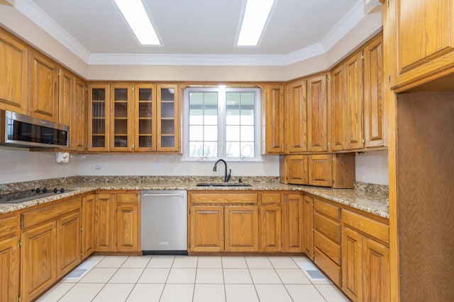 kitchen with light stone counters, a sink, brown cabinets, and stainless steel appliances