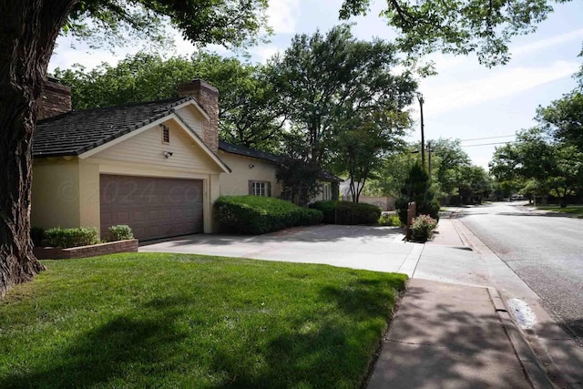 2200 Parker St, Amarillo, TX 79109 - view of side of home with a chimney, a lawn, an attached garage, concrete driveway, and stucco siding