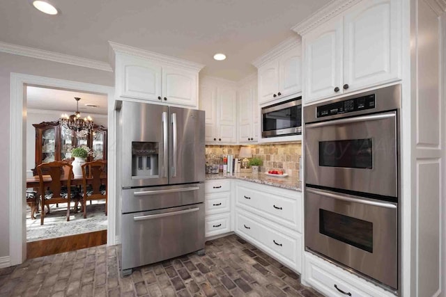 2200 Parker St, Amarillo, TX 79109 - kitchen with appliances with stainless steel finishes, a chandelier, white cabinetry, light stone counters, and crown molding