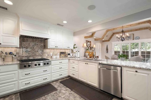 2200 Parker St, Amarillo, TX 79109 - kitchen featuring appliances with stainless steel finishes, a sink, tasteful backsplash, white cabinets, and a chandelier
