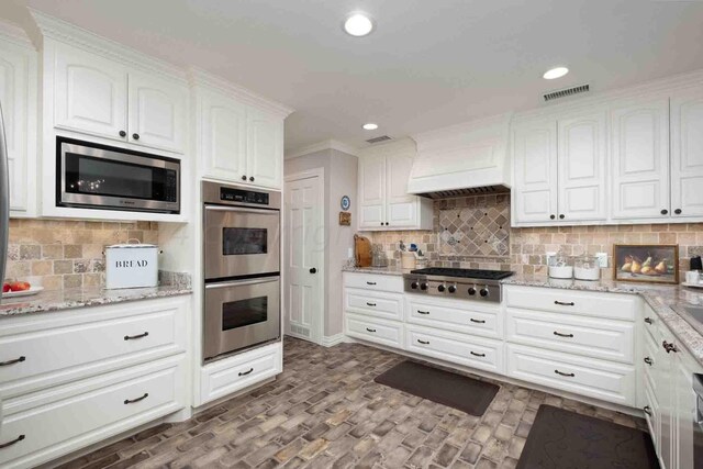 2200 Parker St, Amarillo, TX 79109 - kitchen with appliances with stainless steel finishes, white cabinets, decorative backsplash, light stone countertops, and recessed lighting
