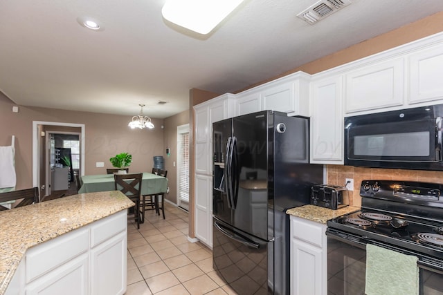 kitchen featuring visible vents, black appliances, and white cabinets