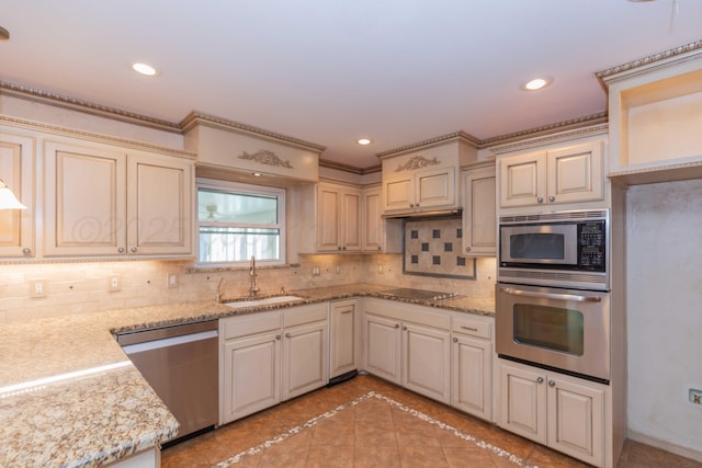 kitchen featuring tasteful backsplash, sink, light stone counters, and stainless steel appliances