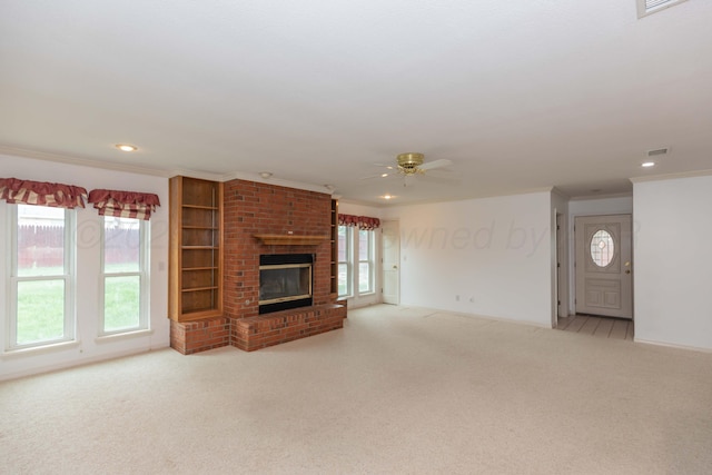 unfurnished living room featuring carpet flooring, ceiling fan, plenty of natural light, and ornamental molding