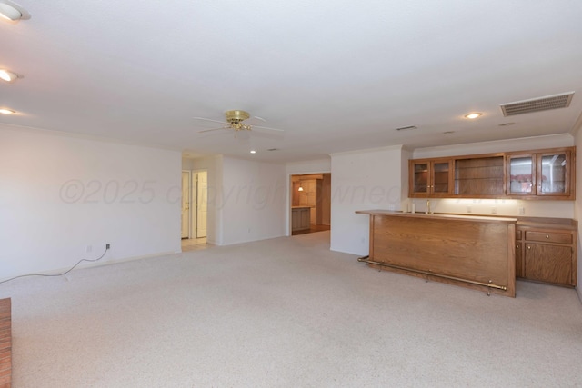 interior space featuring ornamental molding, light colored carpet, and ceiling fan