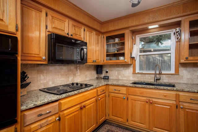 2900 Teckla Blvd, Amarillo, TX 79106 - kitchen with black appliances, decorative backsplash, light stone counters, brown cabinetry, and crown molding