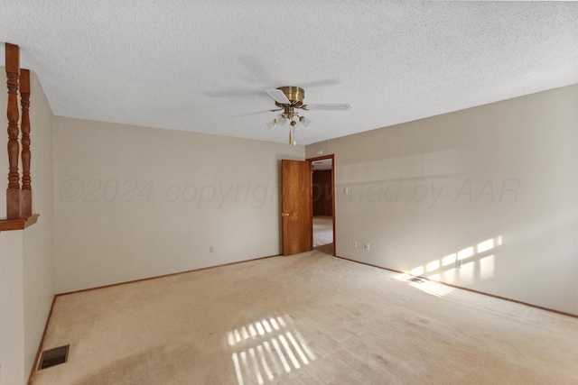 carpeted empty room featuring ceiling fan and a textured ceiling