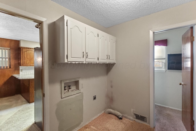 clothes washing area featuring cabinets, washer hookup, hookup for an electric dryer, a textured ceiling, and light carpet