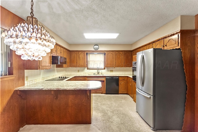 kitchen featuring pendant lighting, an inviting chandelier, black appliances, sink, and kitchen peninsula