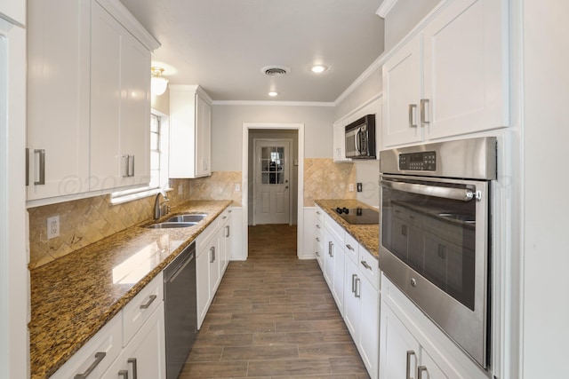3506 Barclay Dr, Amarillo, TX 79109 - kitchen featuring appliances with stainless steel finishes, white cabinets, wood finished floors, dark stone counters, and backsplash