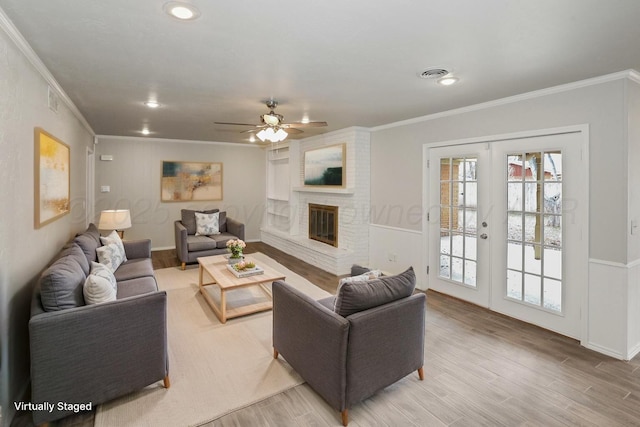 3506 Barclay Dr, Amarillo, TX 79109 - living area with crown molding, light wood finished floors, french doors, a ceiling fan, and a brick fireplace