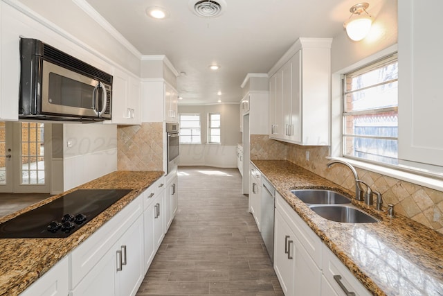 3506 Barclay Dr, Amarillo, TX 79109 - kitchen with appliances with stainless steel finishes, white cabinets, decorative backsplash, wood finished floors, and recessed lighting
