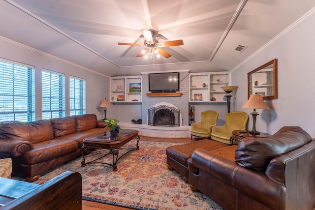 6211 Edgeware Pl, Amarillo, TX 79109 - living room featuring ceiling fan, a brick fireplace, crown molding, wood finished floors, and a raised ceiling