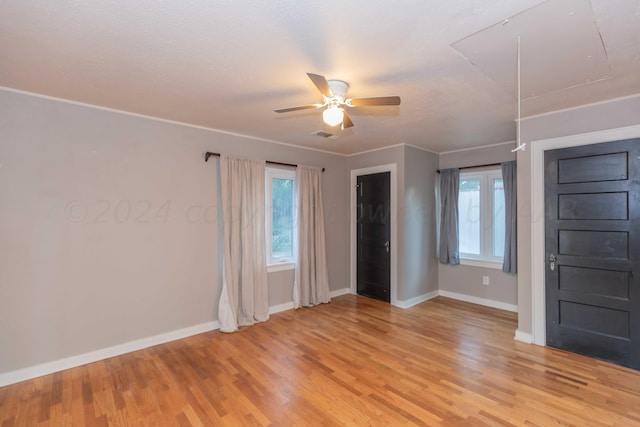 spare room featuring light hardwood / wood-style flooring, ceiling fan, and plenty of natural light