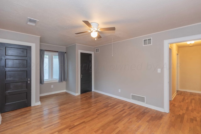 interior space featuring ceiling fan, light hardwood / wood-style floors, and a textured ceiling