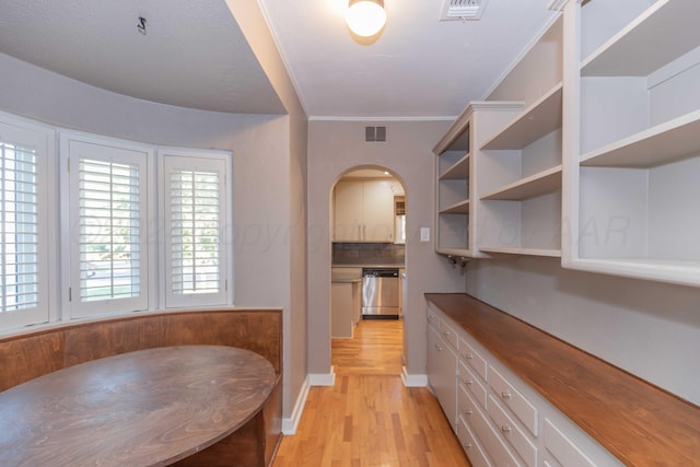 unfurnished dining area with light hardwood / wood-style floors and ornamental molding