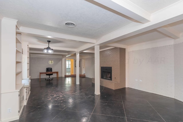 unfurnished living room with built in shelves, beamed ceiling, brick wall, a textured ceiling, and a fireplace