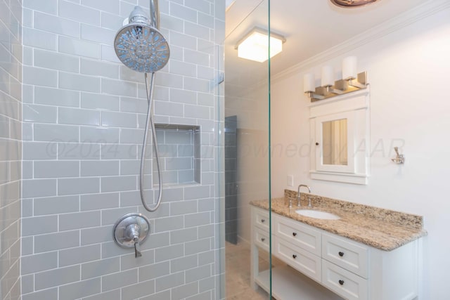 bathroom with a tile shower, crown molding, and vanity